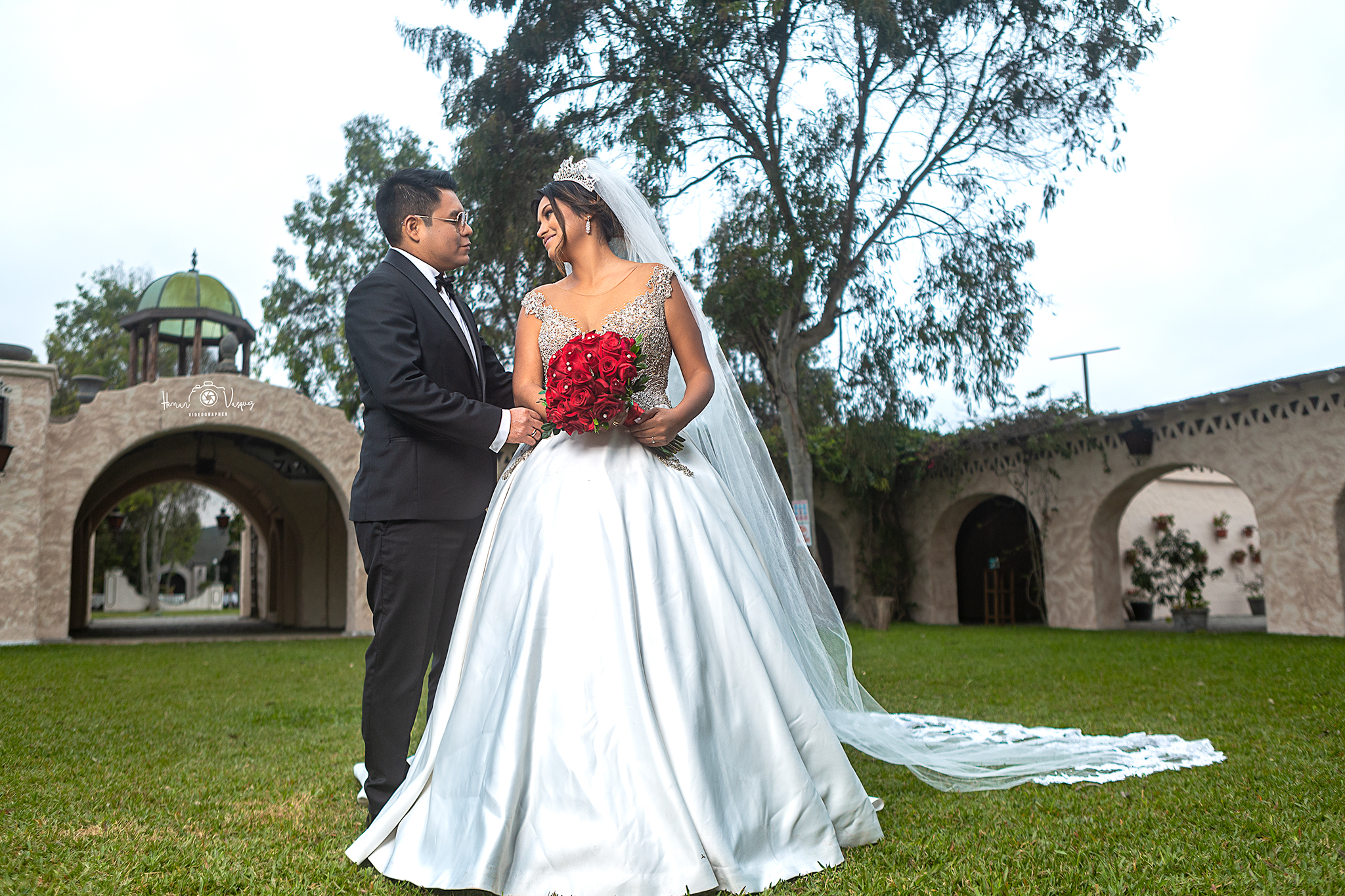 Pareja de recién casados en un jardín con arquitectura de piedra
