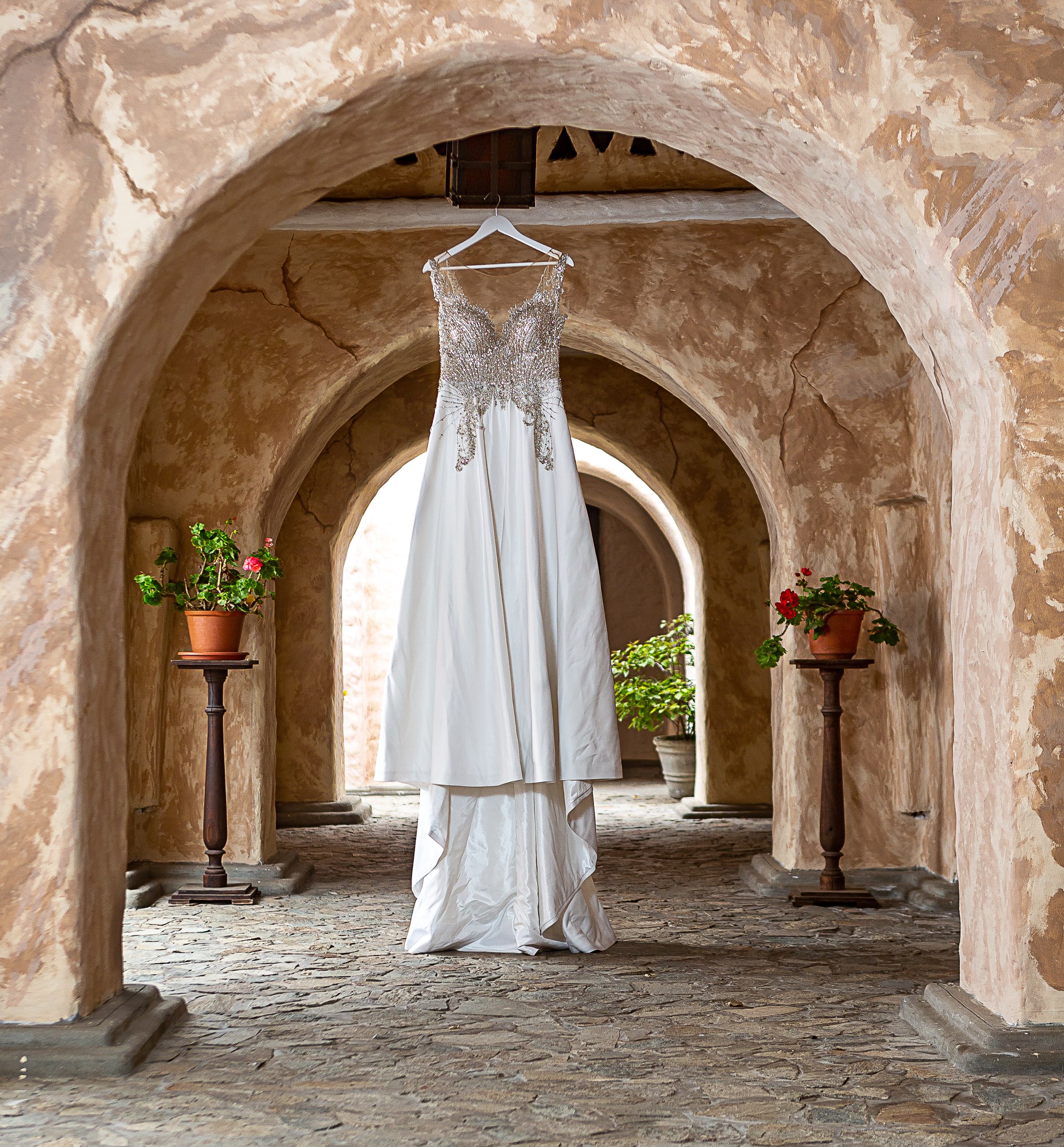 Vestido de novia colgado bajo un arco de piedra