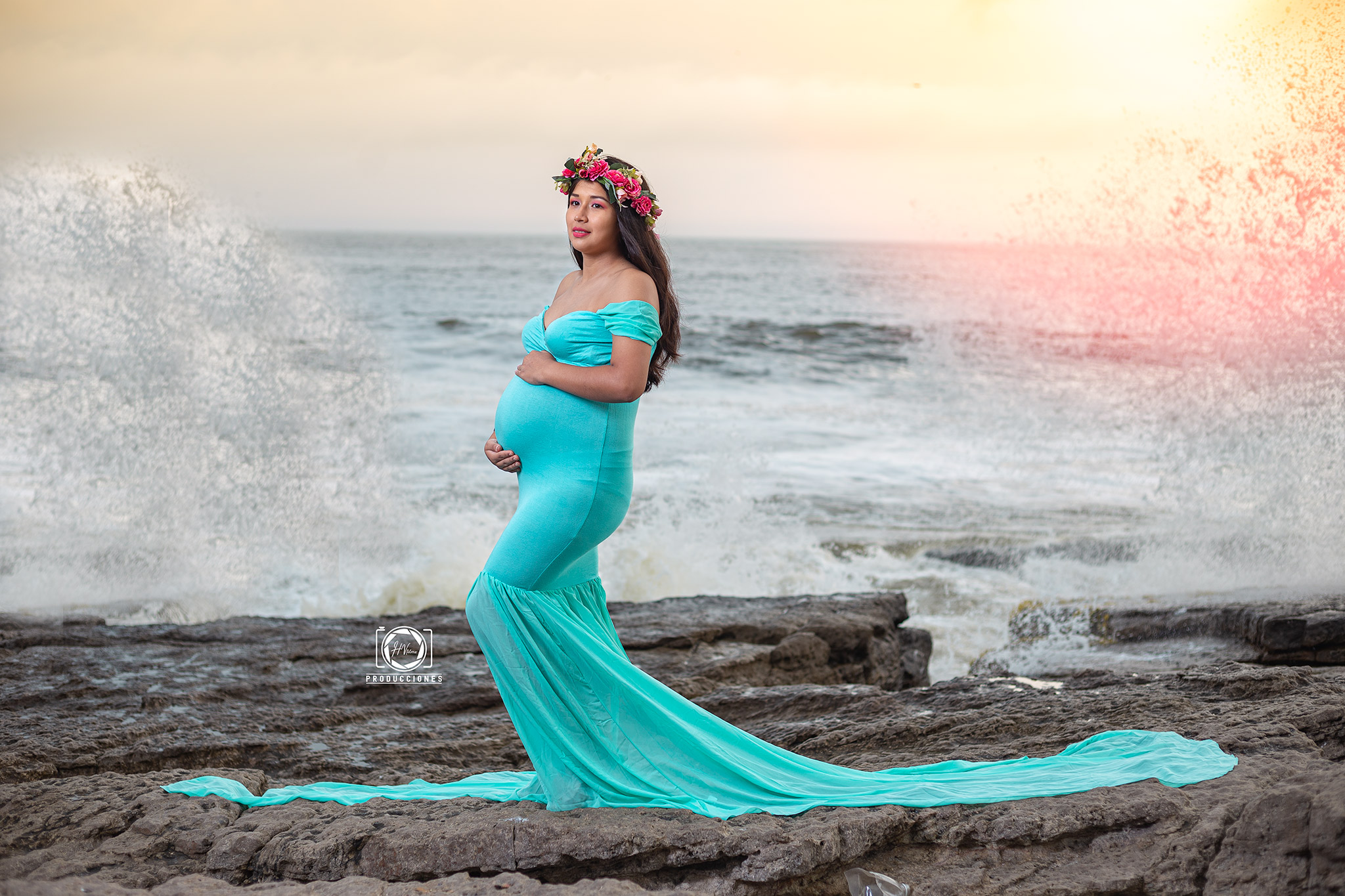 Retrato de embarazo con vestido turquesa junto al mar