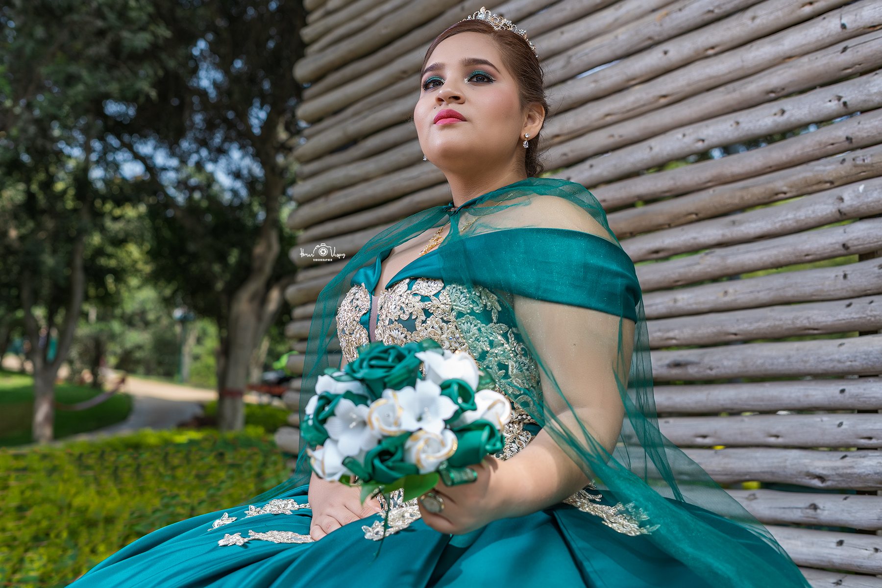 Retrato de quinceañera con vestido verde y ramo